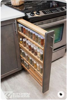 an open cabinet in the middle of a kitchen counter with spices and condiments