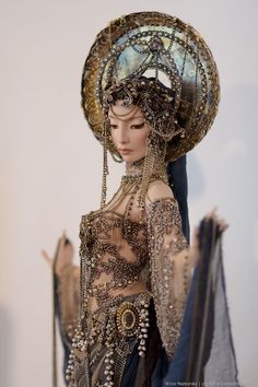 a mannequin dressed in an elaborate dress and headdress with chains on it