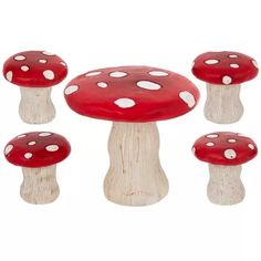 four red mushrooms with white dots on them are sitting in the middle of a group