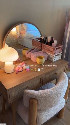 a vanity with a mirror, lamp and other items sitting on top of the table