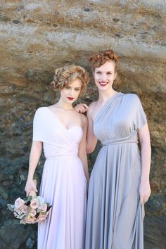 two women standing next to each other in dresses