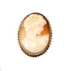 This is a fun hand-carved shell cameo brooch/pendant combination depicting a beautiful young woman's profile gazing to the right. The oval shell cameo is set into 12K yellow gold-filled metal and secures with a modern safety clasp and a collapsible bail. The brooch is framed with a simple twisted ribbon pattern that adds a beautiful design element to the piece. A lovely cameo to start or add to your collection!Cameo carving has an ancient history dating back to 3 century BCE Greece. Empress Jose Oval Brooches For Formal Occasions, Cabochon Brooches As A Gift, Victorian Style Brooches For Gift, Carved Brooches For Formal Occasions, Cameo Brooches For Wedding, Classic Oval Brooches, Collectible Cabochon Brooches, Luxury Oval Cameo Brooch, Classic Oval Cameo Brooch