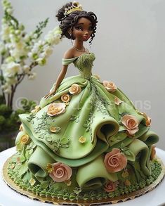 there is a cake made to look like a woman in a green dress with flowers on it