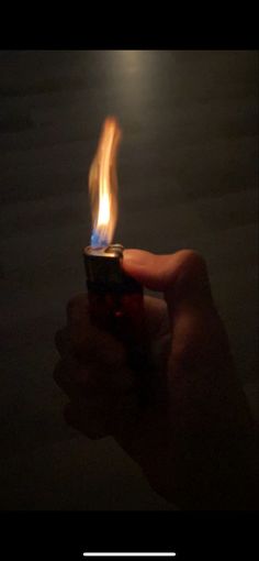 a person holding a lighter in their hand with the light on it's side