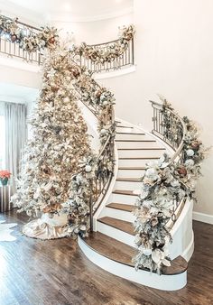 a decorated christmas tree next to a spiral staircase