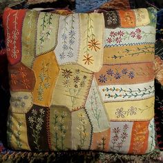 a decorative pillow is on display in a room with many different colors and patterns,