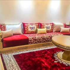 a living room filled with lots of red and gold furniture