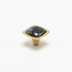 a gold and labradorite ring on a white background