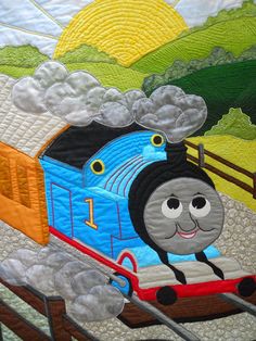 a quilted wall hanging with a thomas the train on it