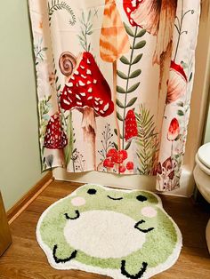 a bathroom with a shower curtain, rug and toilet seat cover in the shape of a mushroom