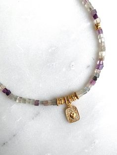 DAFNE NECKLACE Fluorite beaded necklace with gold plated details and heart pendant Dimensions: Total necklace length  40cm / 15.74 in + 5cm / 1.96in  extender chain Weight: 20gr DELIVERY (estimate delays) Greece: 2-5 business days via ELTA  Europe: 5-10 business days via Hellenic Post International: 10-21 business days via Hellenic Post You can shorten considerably your delivery times by upgrading to DHL Express services at checkout.  All PURE GREEK Jewels  are inspired from the ancient greek arts, folklore traditions and world cultures. Our jewelry are handmade with love and imagination so you can enjoy unique creations.   I use mineral and semi-precious stones, crystals, real pearls,  gold plated brass metal, wooden elements, greek and oriental charms, pompons and feathers. I only use hi Adjustable Gold Beaded Necklace With Heart Charm, Semi Precious Stone Jewelry, Fluorite Necklace, Heishi Necklace, Gold Heart Pendant, Semiprecious Stone Jewelry, Heart Pendant Gold, Stacked Jewelry, Trendy Necklaces