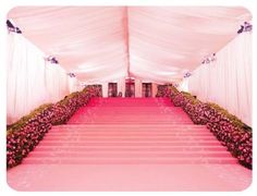 the aisle is lined with pink flowers and white drapes