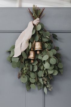 a wreath with bells and greenery hangs on the front door