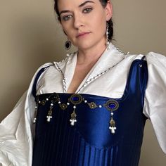 Handcrafted replica period jewelry, made to imitate the style and grandeur of the Tudors. This elegant bodice jewelry will complement any renaissance garb, and elevate even the most simple gown into a piece fit for a queen. It is made to order in your choice of gold, silver, or bronze and can be set with resin gemstones of just about any color. Ruby, emerald, sapphire, amethyst and onyx are most popular options. The Joan has 4 geometric metal cabochons connected by alternating pearl and metal ac Elegant Medieval Dress For Festivals, Elegant Medieval Dress For Larp With Historical Design, Elegant Medieval Dress For Costume Parties And Festivals, Elegant Medieval Dress For Costume Events, Elegant Medieval Dress For Festivals And Costume Parties, Elegant Medieval Dress Costume For Festivals, Elegant Medieval Dress For Costume Party, Tudor Gown, Simple Gown