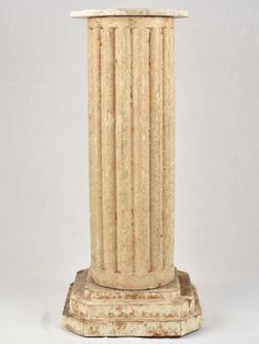 an old stone pedestal with two columns on it's sides and one column in the middle