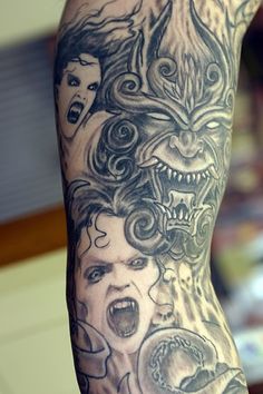 a man's arm with tattoos on it and an image of a demon in the background