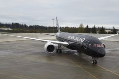 an airplane is parked on the tarmac with trees in the background