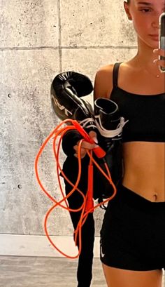 a woman holding a cell phone in her right hand and an orange string attached to it