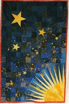 a quilted wall hanging with stars in the sky and sun on it's side