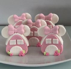 a pink and white cake with minnie mouse ears on it's top is sitting on a plate