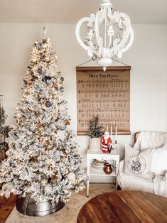 a living room with a christmas tree in the corner and a calendar on the wall