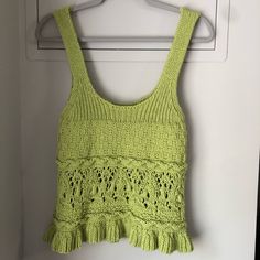 a green tank top hanging on a white door