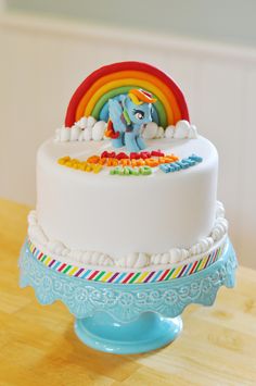 there is a cake that has a rainbow on the top and an elephant on the bottom