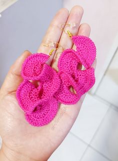 a hand holding three pink crocheted rings