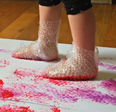 a person standing on top of a white table covered in pink and purple sprinkles