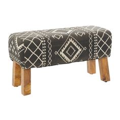 an upholstered bench with wooden legs and a black and white pattern on it