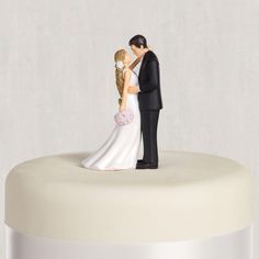 a bride and groom figurine on top of a cake