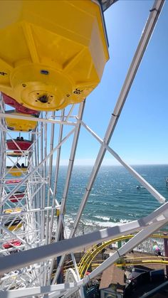 a ferris wheel overlooking the ocean on a sunny day