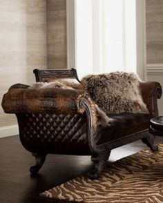 a brown leather chair sitting on top of a wooden floor next to a zebra print rug