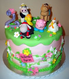 a birthday cake decorated with farm animals and flowers