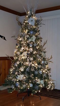 a decorated christmas tree with silver and white ornaments