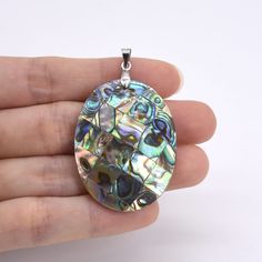 Type:Abalone/paua shell pendant  Shape:Oval Color:Natural color Luster:High Metal:You can choose silver plated brass or solid 925 Sterling Silver (925 Stamped) Size:40x30mm The pendant is one-side laminated with abalone shell.  The pendant doesn't come with a chain or leather cord. You can choose some of our chain/cord from below link: https://www.etsy.com/shop/YouPearl?search_query=chain Mother Of Pearl Shell Pendant As Gift, Silver Shell Necklace With Natural Stones As Gift, Silver Shell Necklace With Natural Stones, Abalone Shell Pendant As A Gift, Abalone Shell Pendant As Gift, Silver Abalone Shell Necklace Gift, Abalone Shell Pendant Gift, Shell-shaped Pearl Pendant For Beach, Ocean-inspired Shell-shaped Pearl Pendant