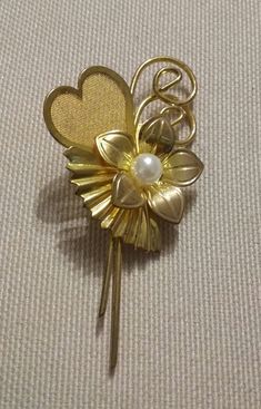 Beautiful vintage Flower brooch, in faux gold, with faux pearl This is such a lovely ittle decorative floral and heart brooch. Measuring 2.5 inches (6 cms) long and1.25 inches (3 cms)wide it has a lovely flower design with a nestling faux pearl, and with a romantic mesh heart. It is in excellent vintage condition. Presented in an Organza gift bag. Please let me know if you have any questions. Thanks for stopping by. Flower With Heart, 1960s Costume, Heart Vintage, Heart Brooch, Pearl Flower, Organza Gift Bags, Flower Brooch, Vintage 1960s, Vintage Flowers