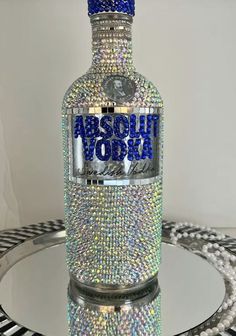 a bottle that is sitting on top of a glass table with some beads around it