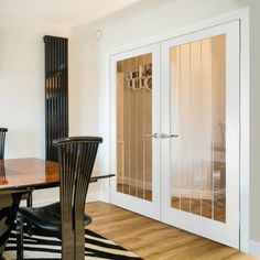 a dining room table and chairs with glass doors