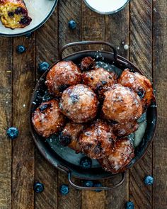 blueberry muffins in a pan with powdered sugar on top