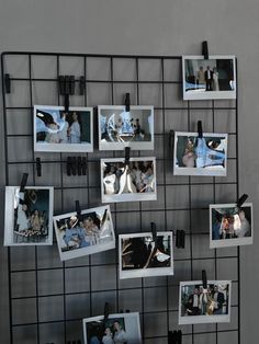 several pictures hanging on a wall with clips and magnets attached to the pegs