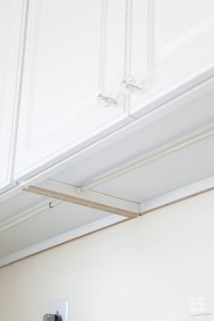 a kitchen with white cupboards and an electrical outlet