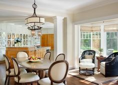 a dining room table with chairs and a bowl of fruit on it