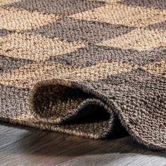 a close up of a rug on the floor with a wooden floor in the background