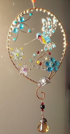 a wind chime hanging from the ceiling with beads and lights on it's sides