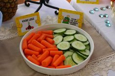 a bowl filled with cucumbers and carrots on top of a table