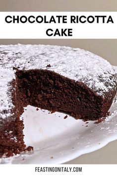 a chocolate ricotta cake on a white plate with the slice cut out and text overlay