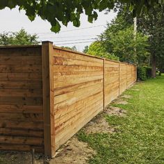 a wooden fence in the middle of a grassy field