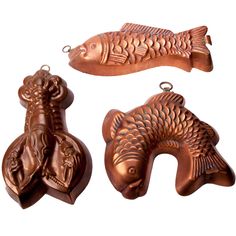 three metal fish ornaments are shown on a white background