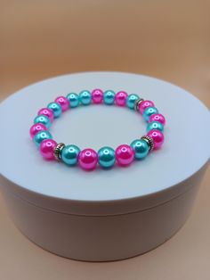 Aqua and pink 8mm pearl bead bracelet. It is a very colorful bracelet that can make a nice gift for your loved ones or for yourself.  Bracelet is crafted with quality elastic stretch cord for the perfect fit. Bracelet sizes are from 6.5 inches to 8 inches. If your wrist size is not listed then please contact me with your wrist size. I will gladly do a special order. All items are made to order. They are shipped via United States Postal Service with a tracking number. Items will be shipped within Pink Beaded Party Bracelets, Pink Beaded Bracelets With 8mm Beads For Birthday, Pink Round Bead Bracelets For Birthday Gift, Pink Round Beads Bracelets For Birthday Gift, Pearl Stretch Bracelet With 8mm Beads As Gift, Pink Round Beads Bracelet For Birthday, Pink Beaded Stretch Bracelet For Birthday, Pink Stretch Bracelet With Round Beads For Birthday, Turquoise Pearl Bracelet As A Gift